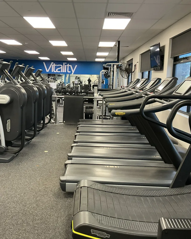 The cardio line at Berri: a row of treadmills beside cross-trainers, with the Vitality wall behind